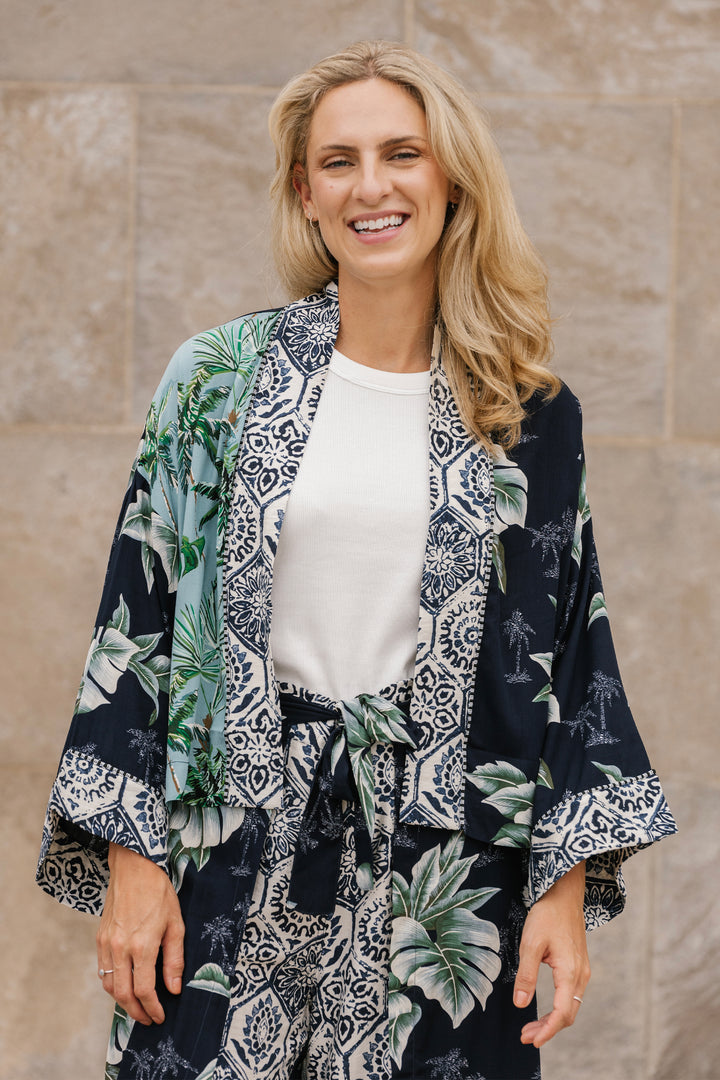 Woman wearing a patterned kimono against a beige wall