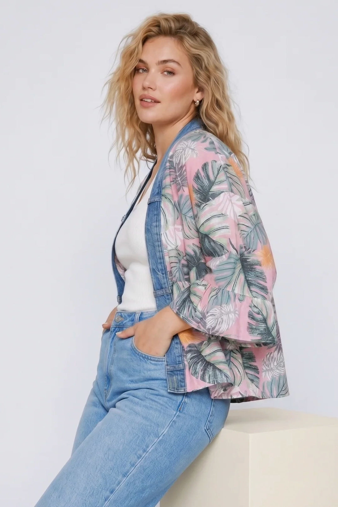 Woman wearing a floral jacket and jeans on a white background