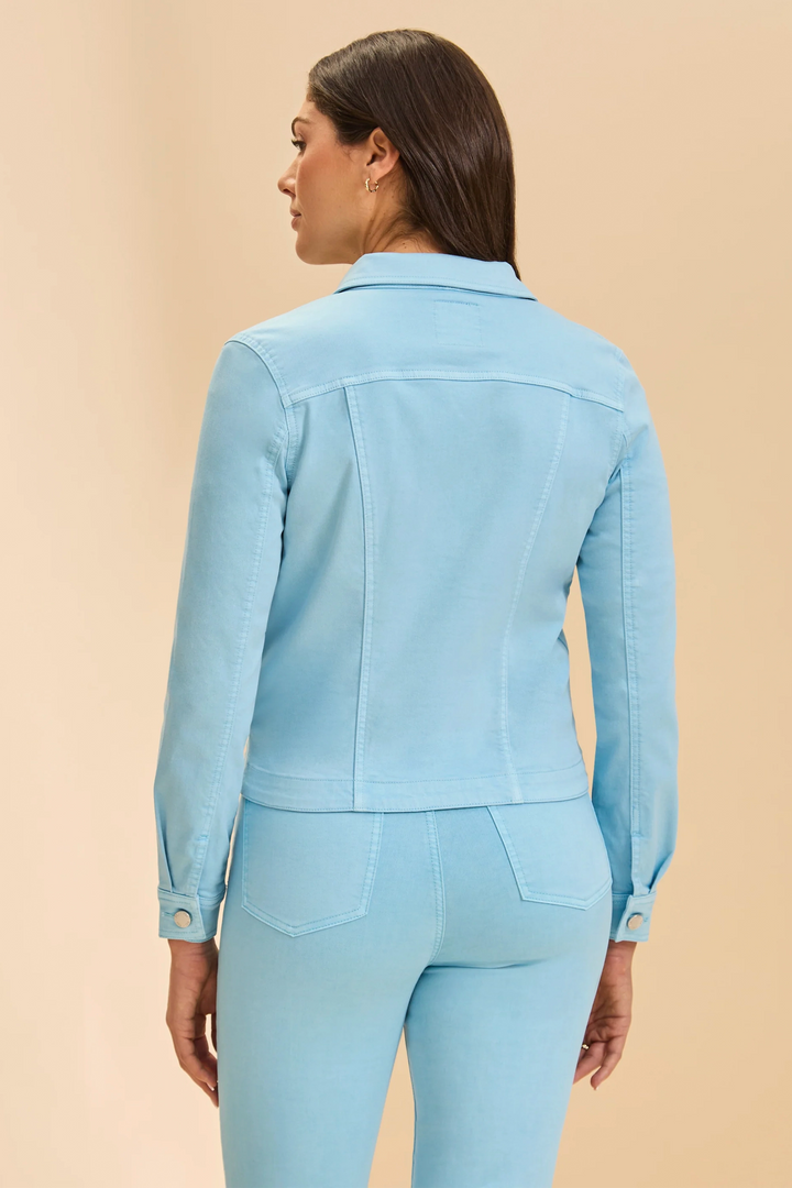 Woman wearing a light blue jacket and pants on a beige background