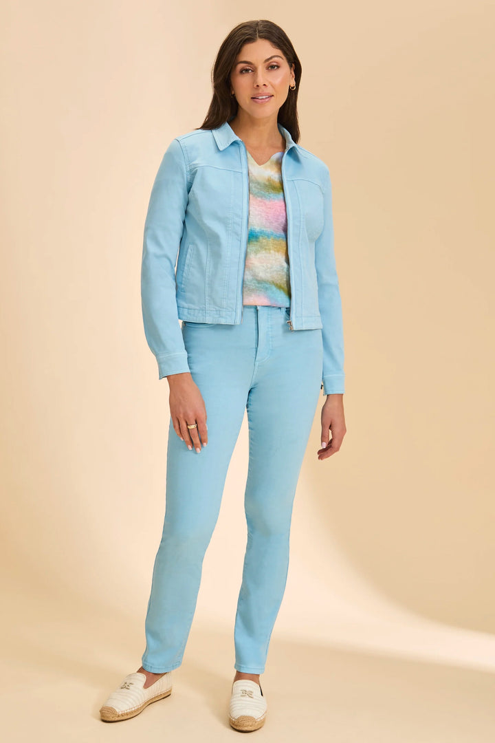 Woman wearing a light blue outfit with a jacket, shirt, and pants on a beige background