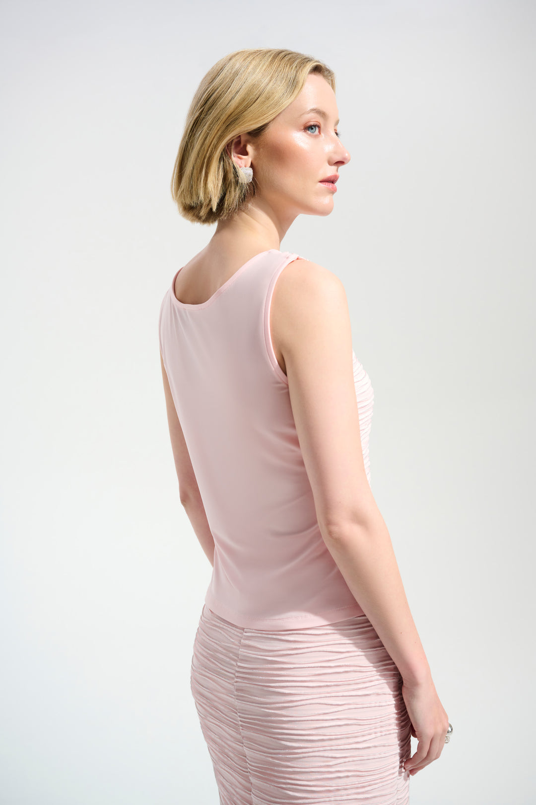 Woman wearing a light pink dress against a white background