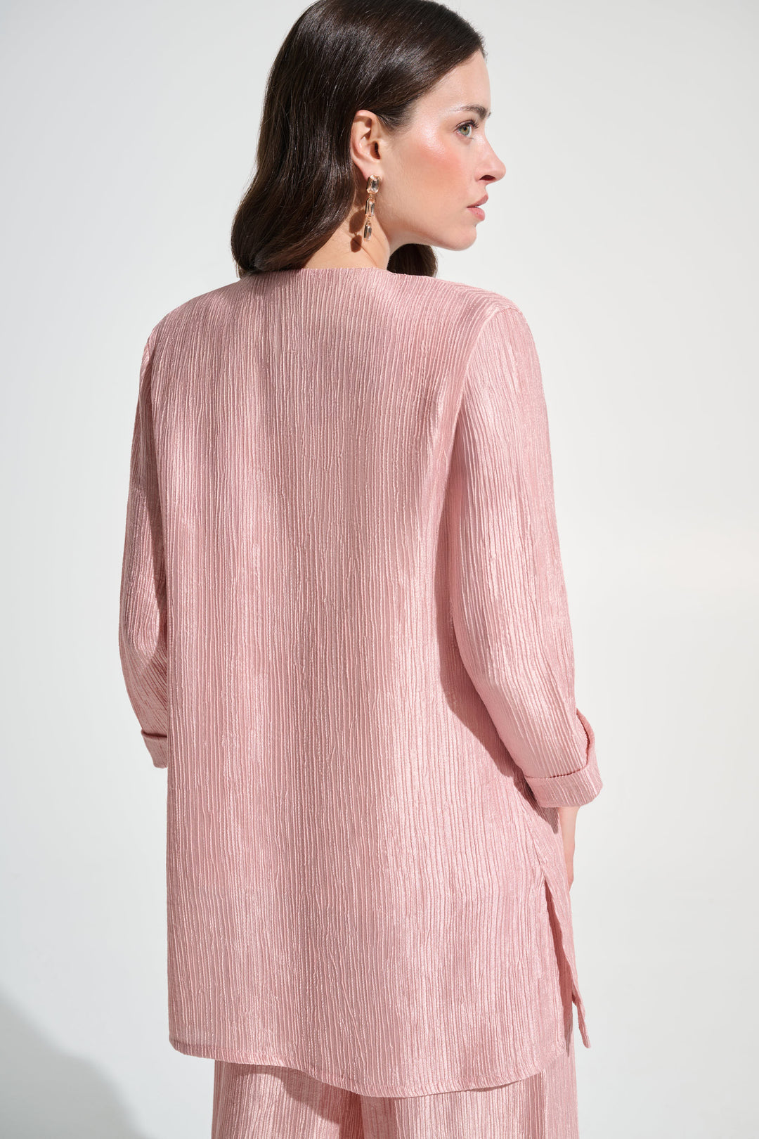 Woman wearing a pink outfit with a plain background