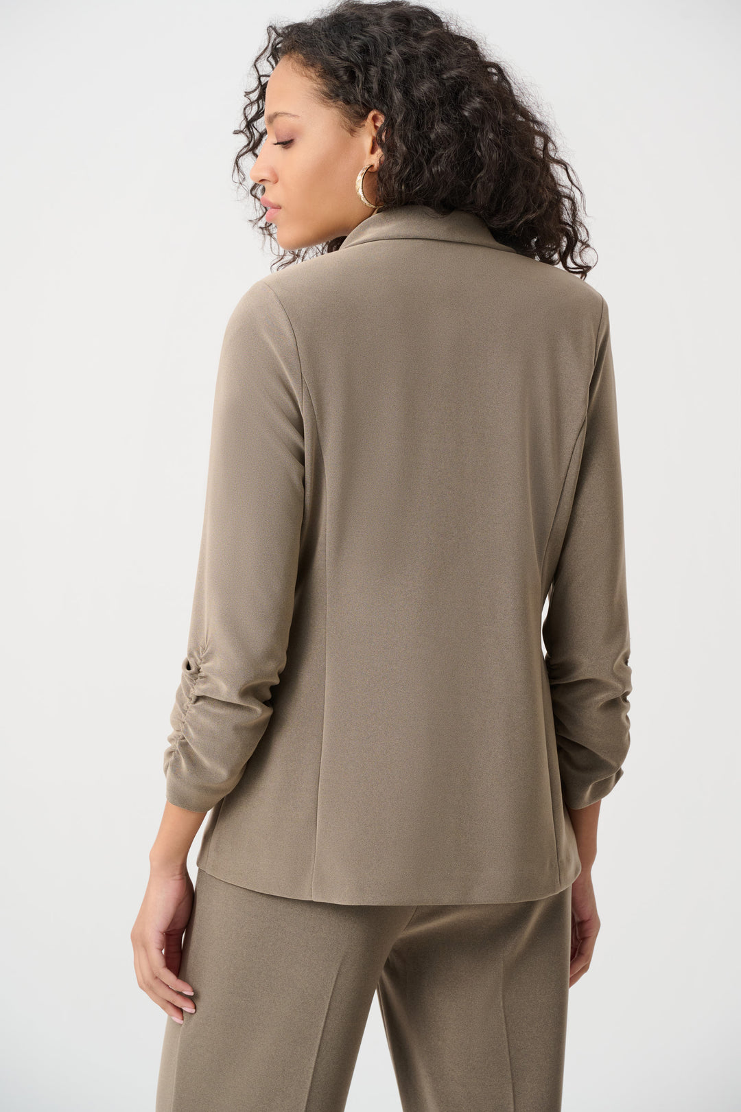 Woman wearing a taupe suit against a white background