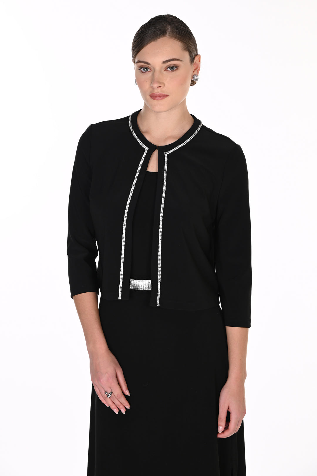 A woman modeling a black three-quarter sleeve dress with silver rhinestone trim along the neckline, front keyhole, and waistband, set against a plain white studio background.