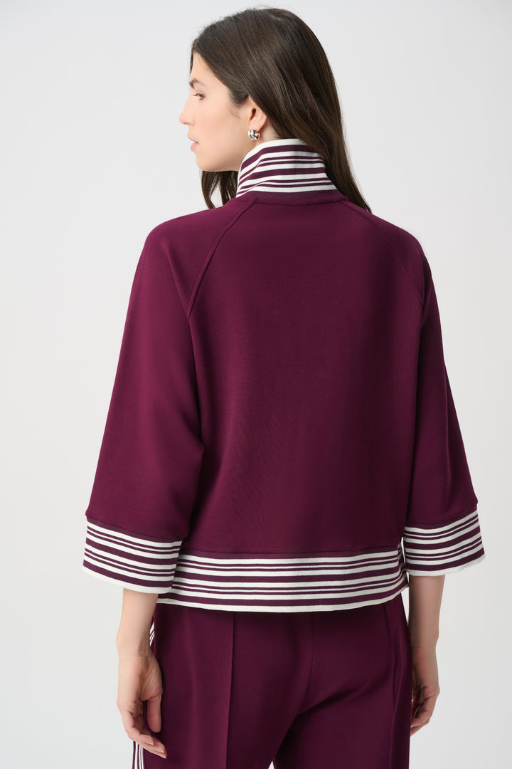 Person wearing a burgundy outfit with white stripes on a plain background