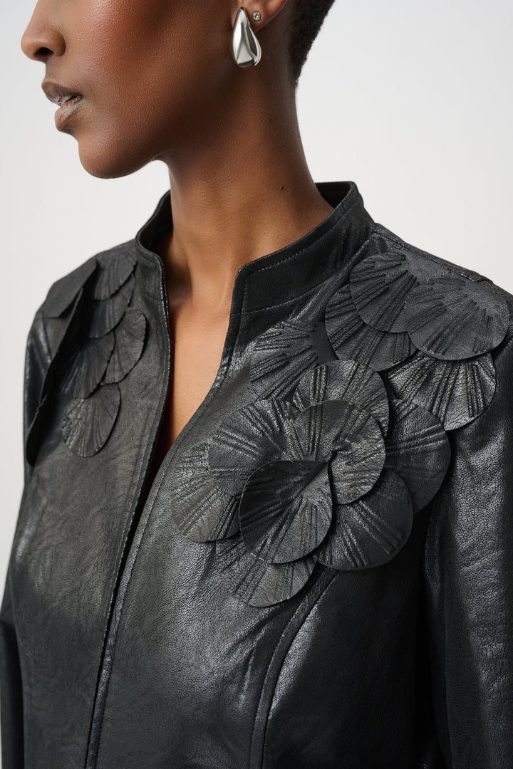 Close up of a woman wearing a black leather jacket with floral embellishments on a white background