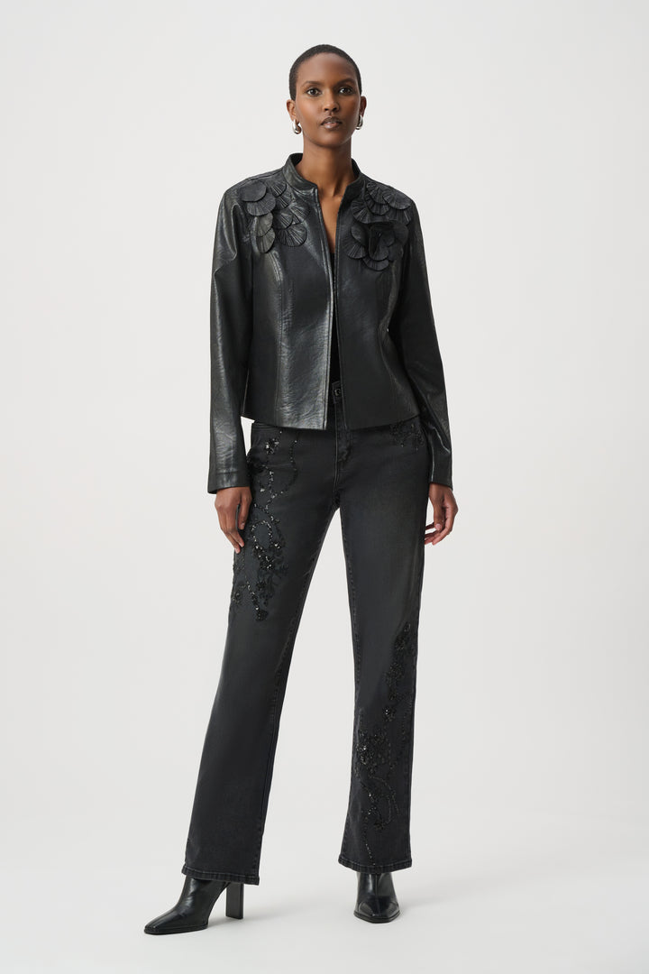 Woman wearing a black leather jacket and pants on a white background