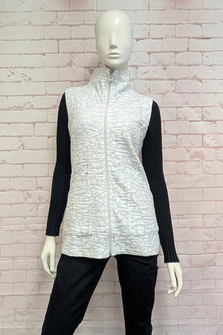 A female mannequin wearing a sleeveless zip-front vest with a high mock neck collar, featuring an abstract white and gray pattern.