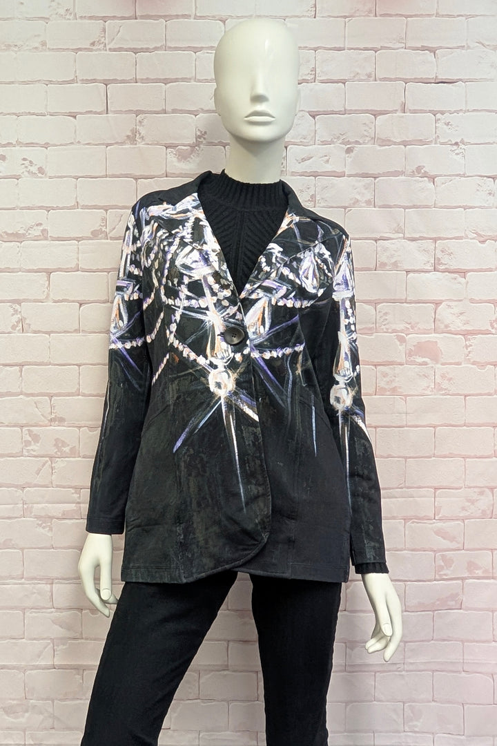 A black long-sleeve blazer with a silver and white metallic web-like pattern, displayed on a white mannequin against a light pink brick wall.
