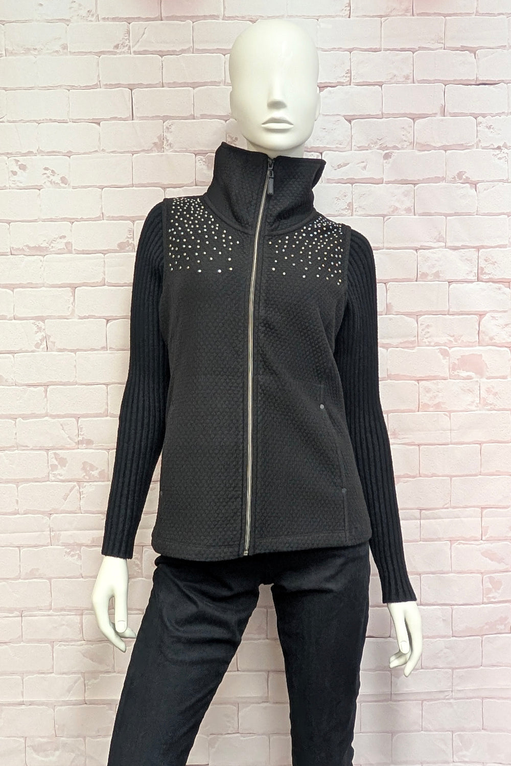 A mannequin wearing a black sleeveless vest with a high mock neck.