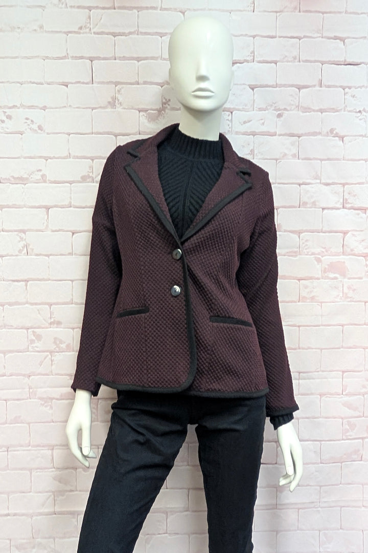 A mannequin wearing a textured knit blazer.