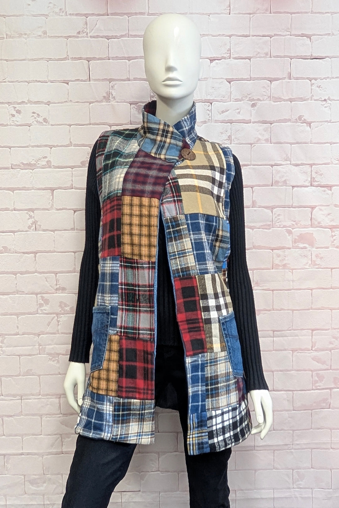 A mannequin wearing a women's patchwork denim and plaid vest.