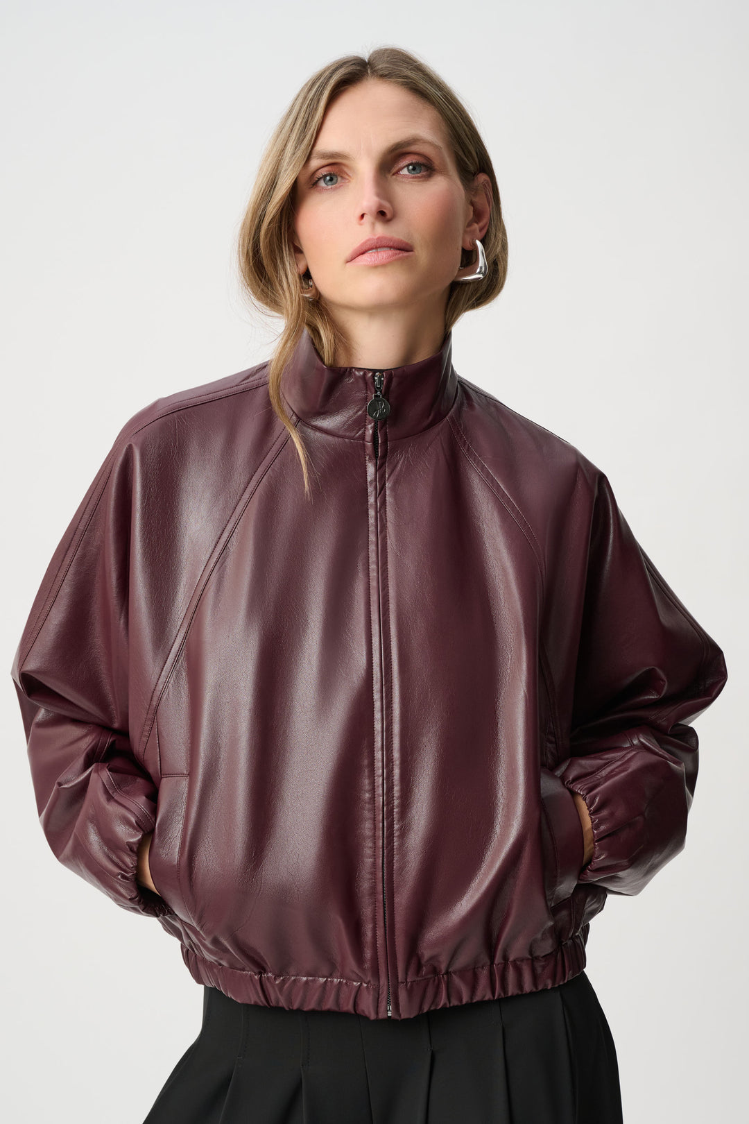 Woman wearing a brown leather jacket on a white background