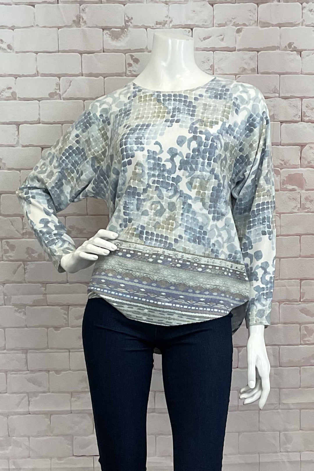 Variations Fall 2024 The round neck and slightly loose fit provide both comfort and style. Perfect for pairing with joggers, jeans or even capris, and featuring a lovely watercolour abstract print with a neat rounded hemline.