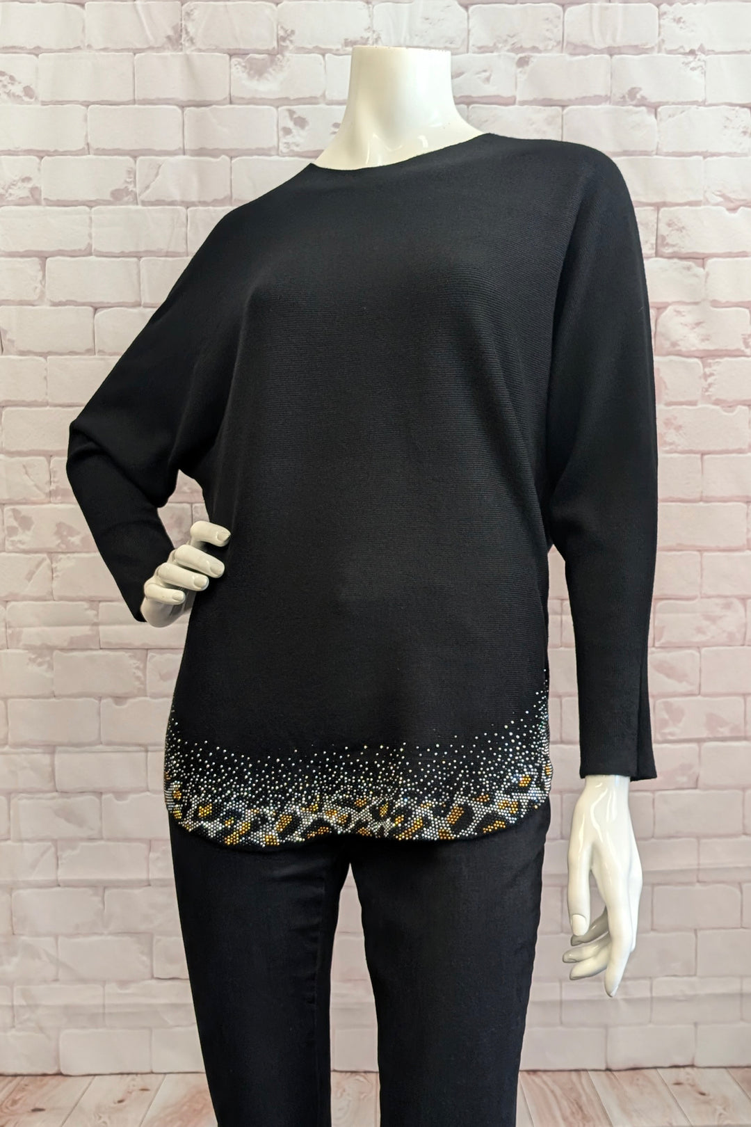 CASA DONNA Fall 2025 
 Its loose silhouette flatters every figure, while the full-length dolman sleeves add a touch of relaxed elegance. The standout feature is the neat rhinestone hem accented with a bold contrast animal print, infusing a hint of glamour and edge into your look. 