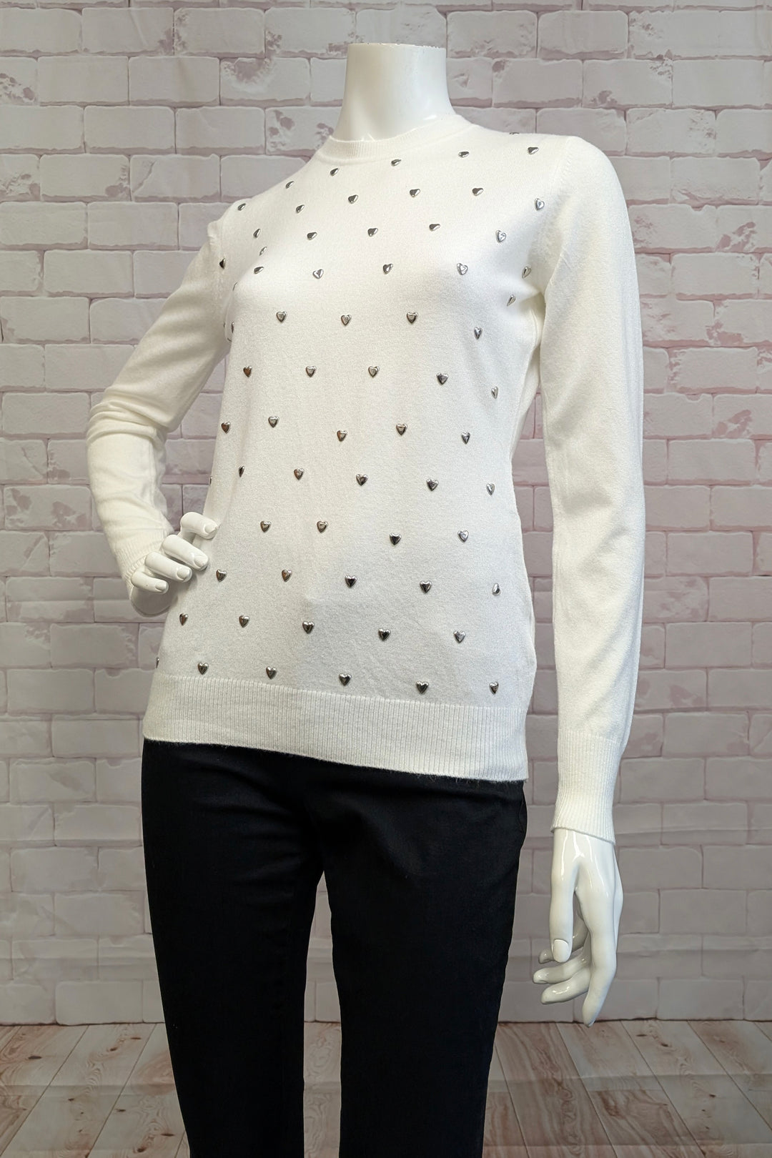 Ness Fall 2025 
This lightweight sweater top features stretch fabric for comfortable wear and a polished look. Its simple knit design and classic round neckline provide versatile style, while charming heart studs at the front add a touch of elegance. 