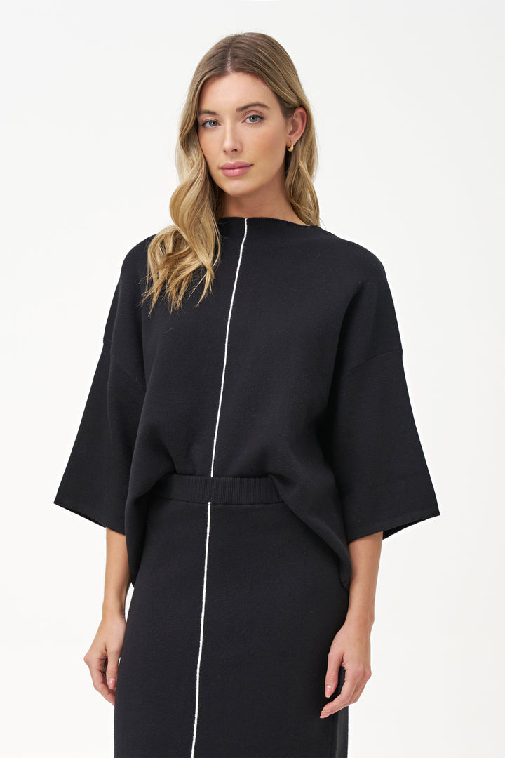 M Italy Fall 2025 
Its loose dolman sleeves offer effortless movement, while the contrasting center seam adds a subtle, chic detail that elevates its simple silhouette. Crafted from soft knit sweater fabric, this top provides warmth without sacrificing breathability.