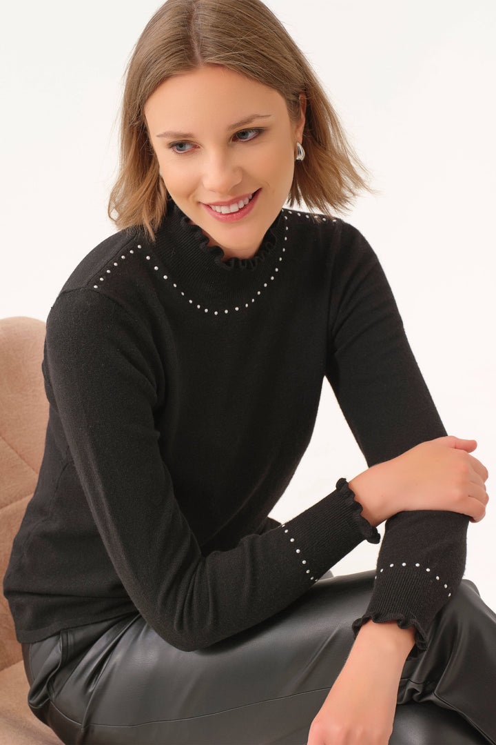 Dolcezza Fall 2025 
With a stunning yet simple design, this top features a high ruffle neck with jewel embellishments along the neckline and cuffs.