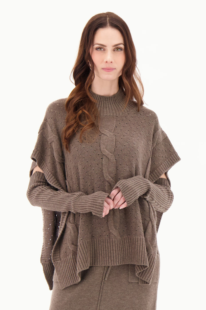 GABBY ISABELLA Fall 2025 
Embrace effortless style with the Cable Knit Poncho, crafted from a stretchy fabric blend for comfort and ease. Its poncho silhouette with open, loose sides allows for easy layering over shirts and blouses, adding warmth without bulk. 