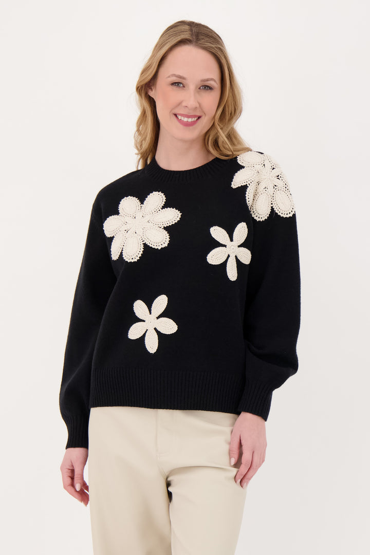 GABBY ISABELLA Fall 2025 
Crafted from a soft, lightweight fine knit fabric, it features delicate flower appliques which are stitched crochet on the front.