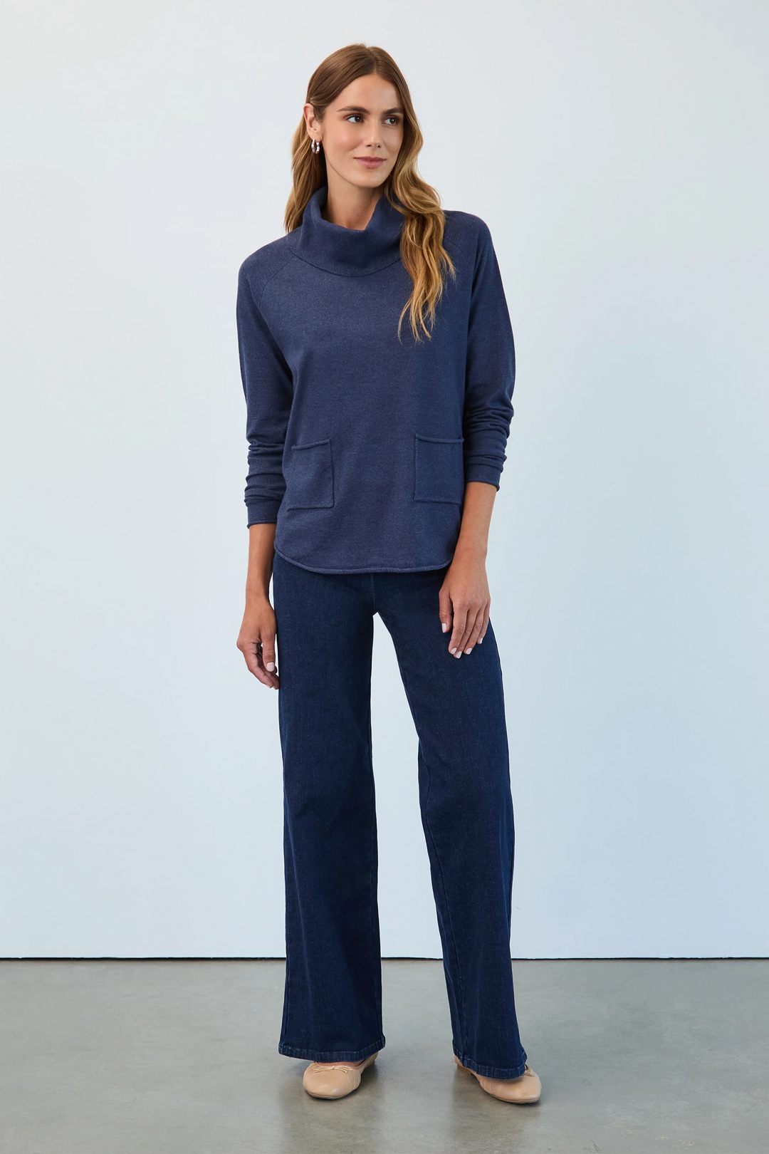 Woman wearing a navy blue outfit against a light gray background