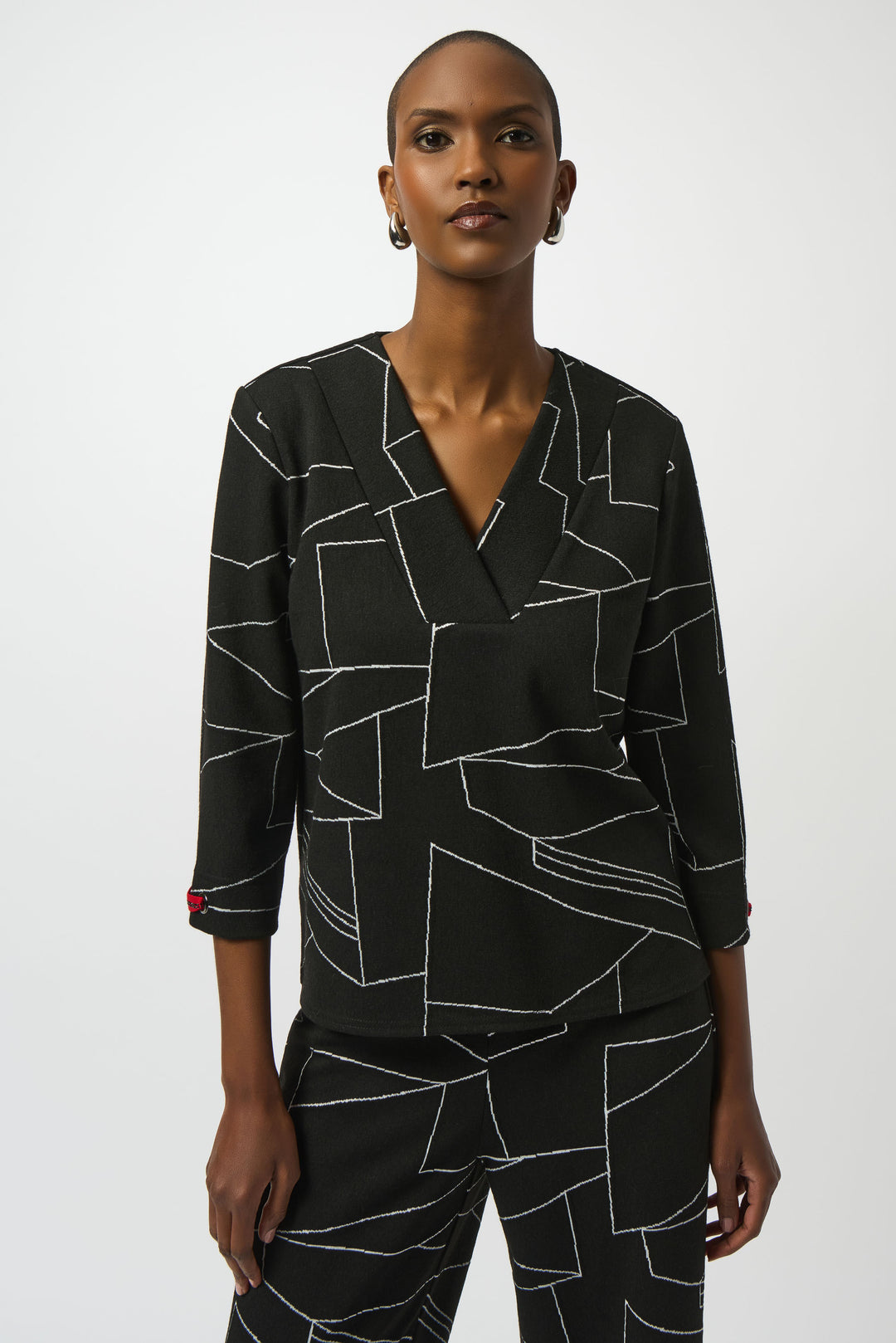 Woman wearing a black geometric patterned outfit on a white background