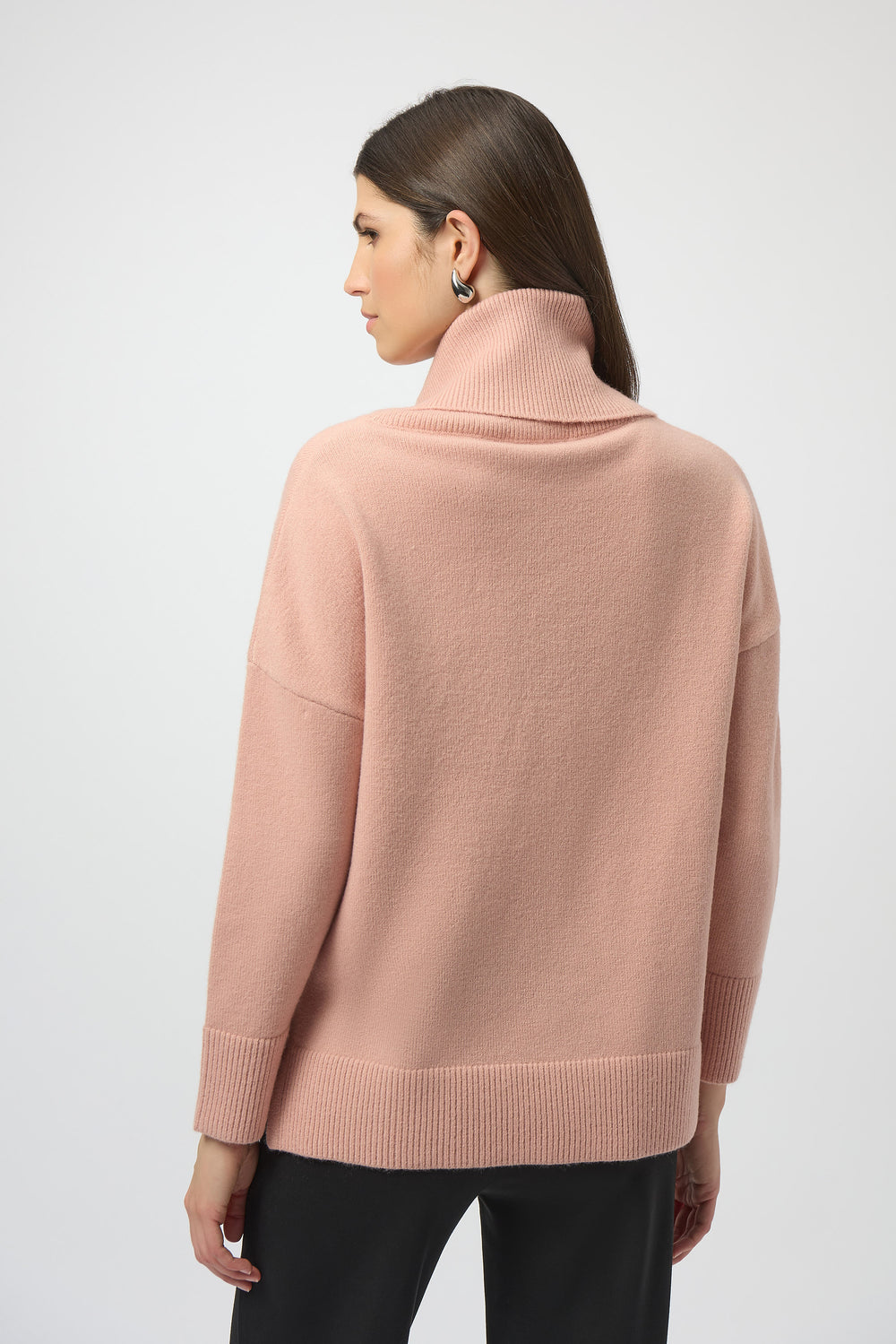 Woman wearing a pink sweater on a white background