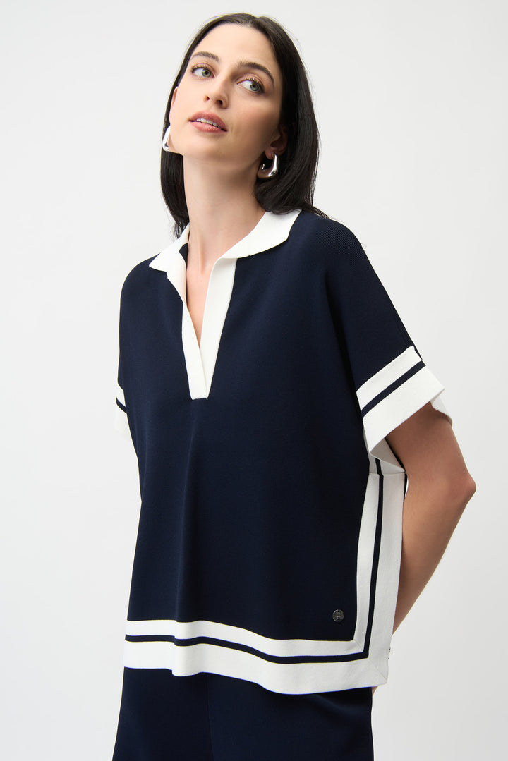 Woman wearing a navy and white blouse against a white background