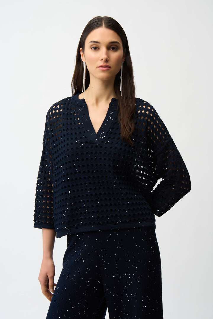 Woman wearing a dark blue textured sweater top and pants on a white background