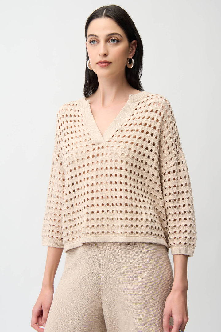 Woman wearing a beige crochet top against a white background