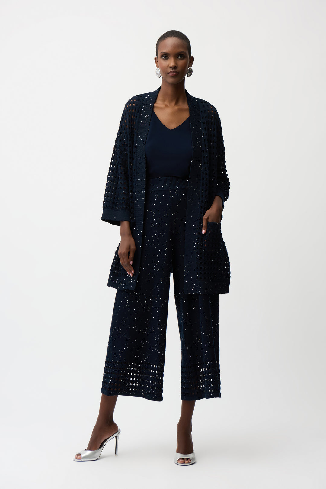 Woman wearing a navy blue outfit with a matching jacket and pants on a white background