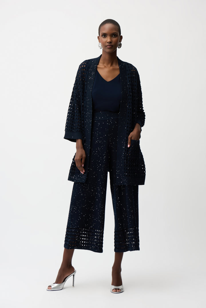 Woman wearing a navy blue outfit with a matching jacket and pants on a white background