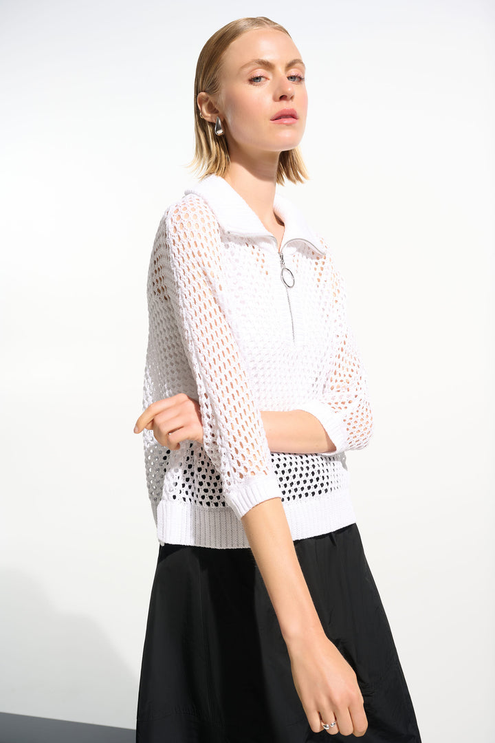 Woman wearing a white mesh cardigan zipper top and black pants on a white background