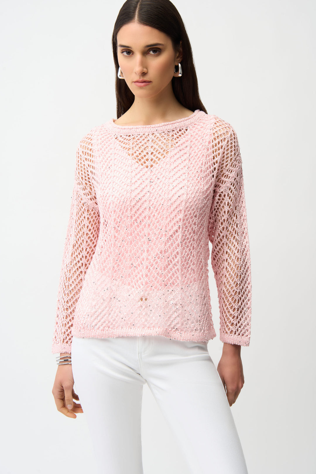 Woman wearing a pink knitted crochet mesh sweater on a white background