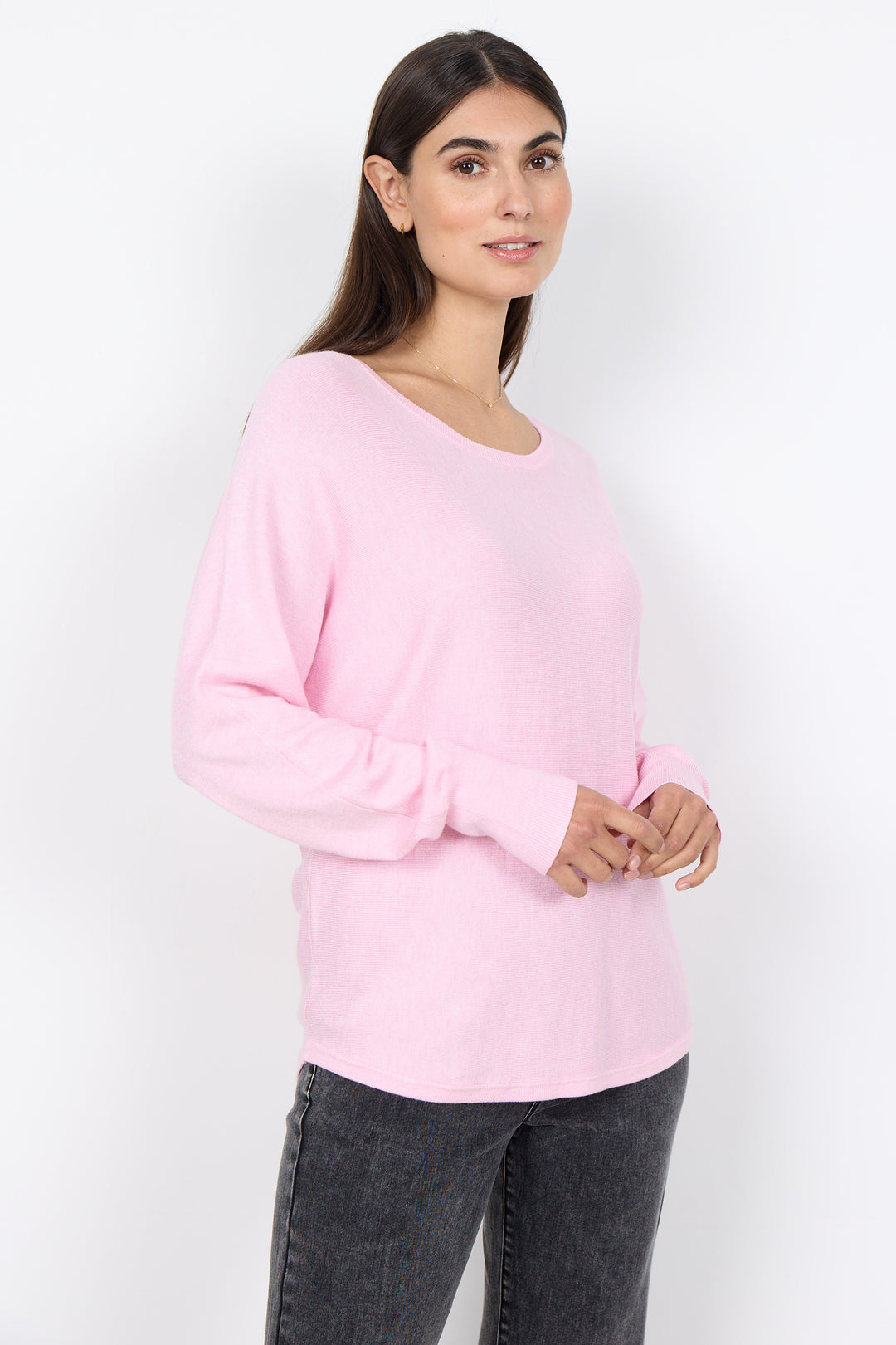 Woman wearing a pink sweater against a white background