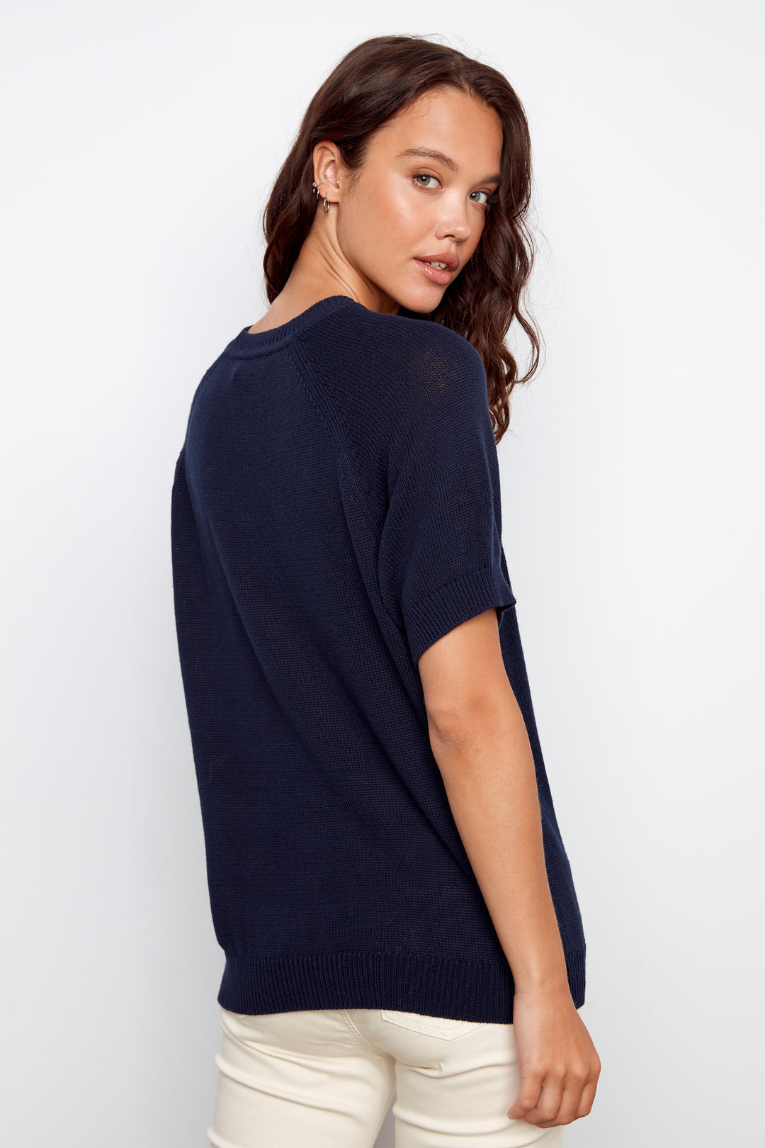 Woman wearing a navy blue sweater against a white background