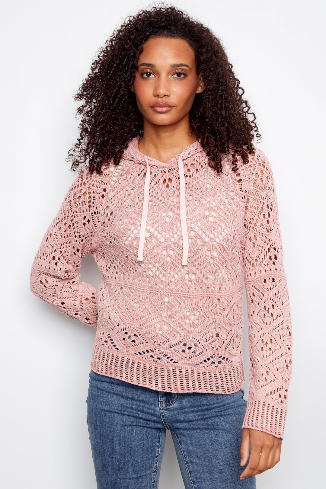 Woman wearing a pink lace hoodie against a white background