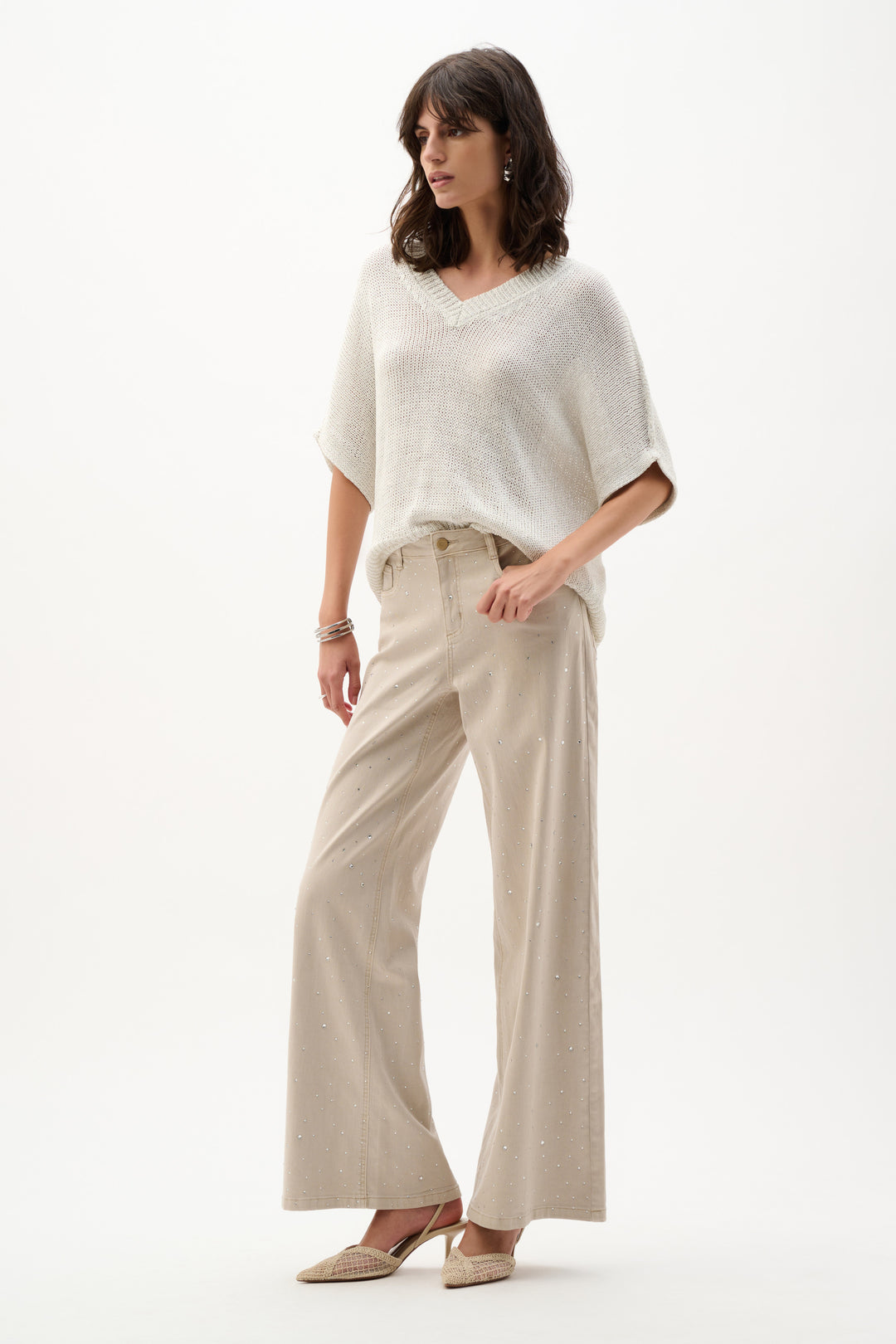 Woman wearing a white top and beige pants on a white background