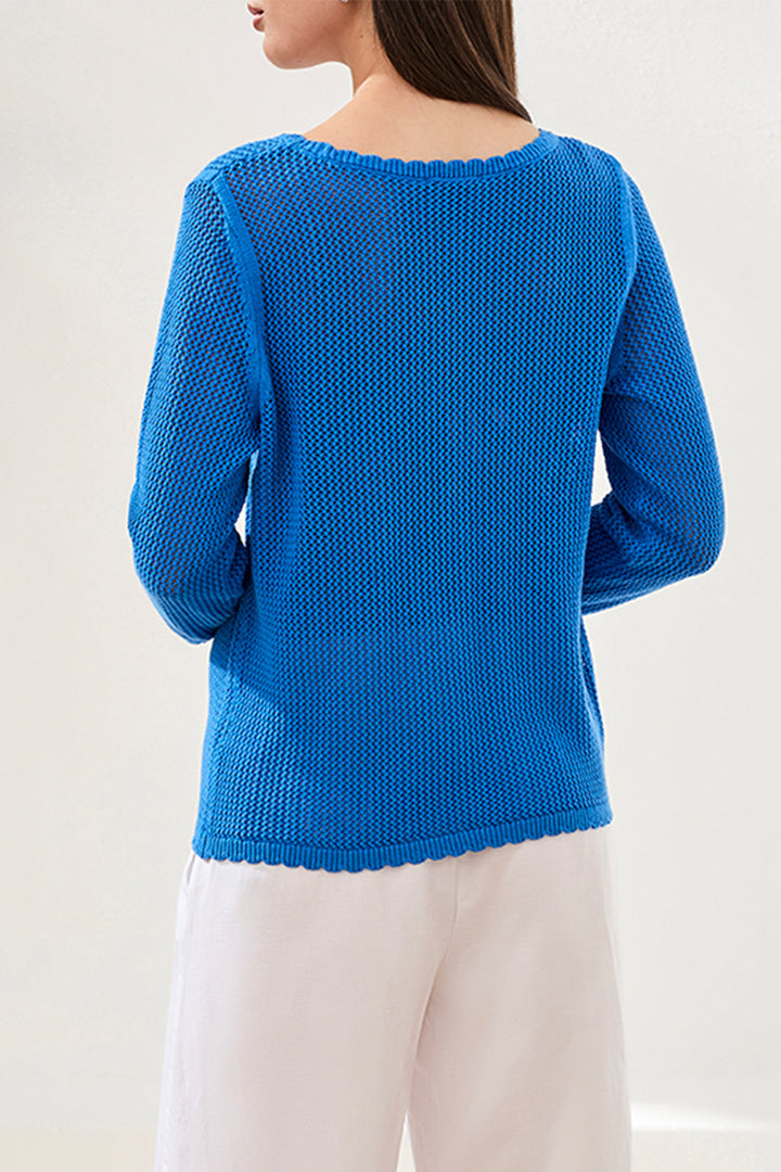 Blue knitted sweater worn by a person on a white background