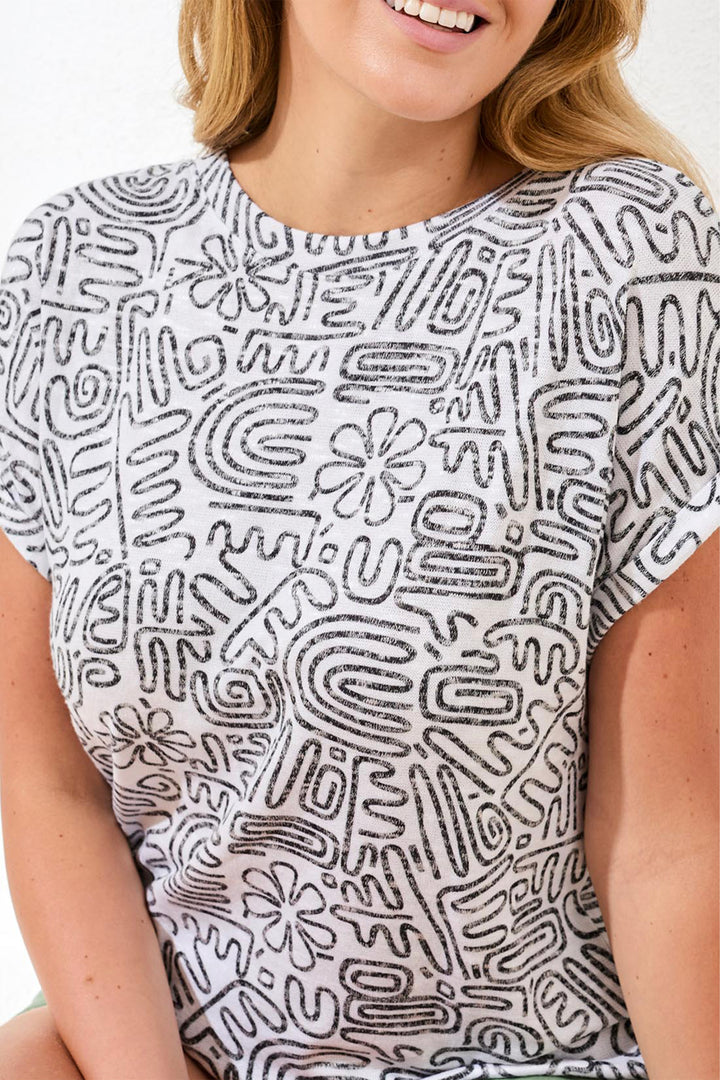 Person wearing a white t-shirt with black abstract pattern