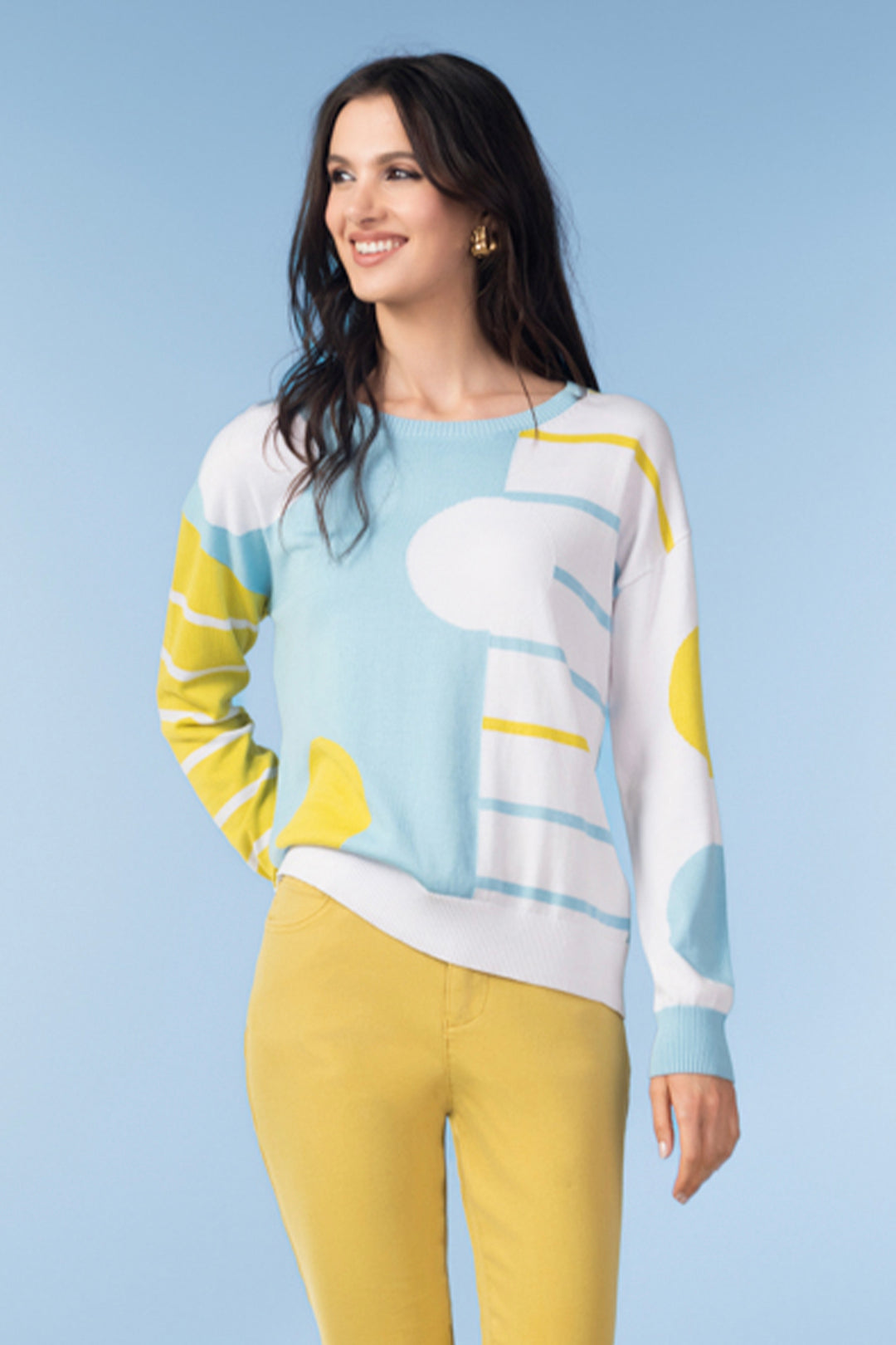 Woman wearing a colorful sweater with cloud design against a light blue background