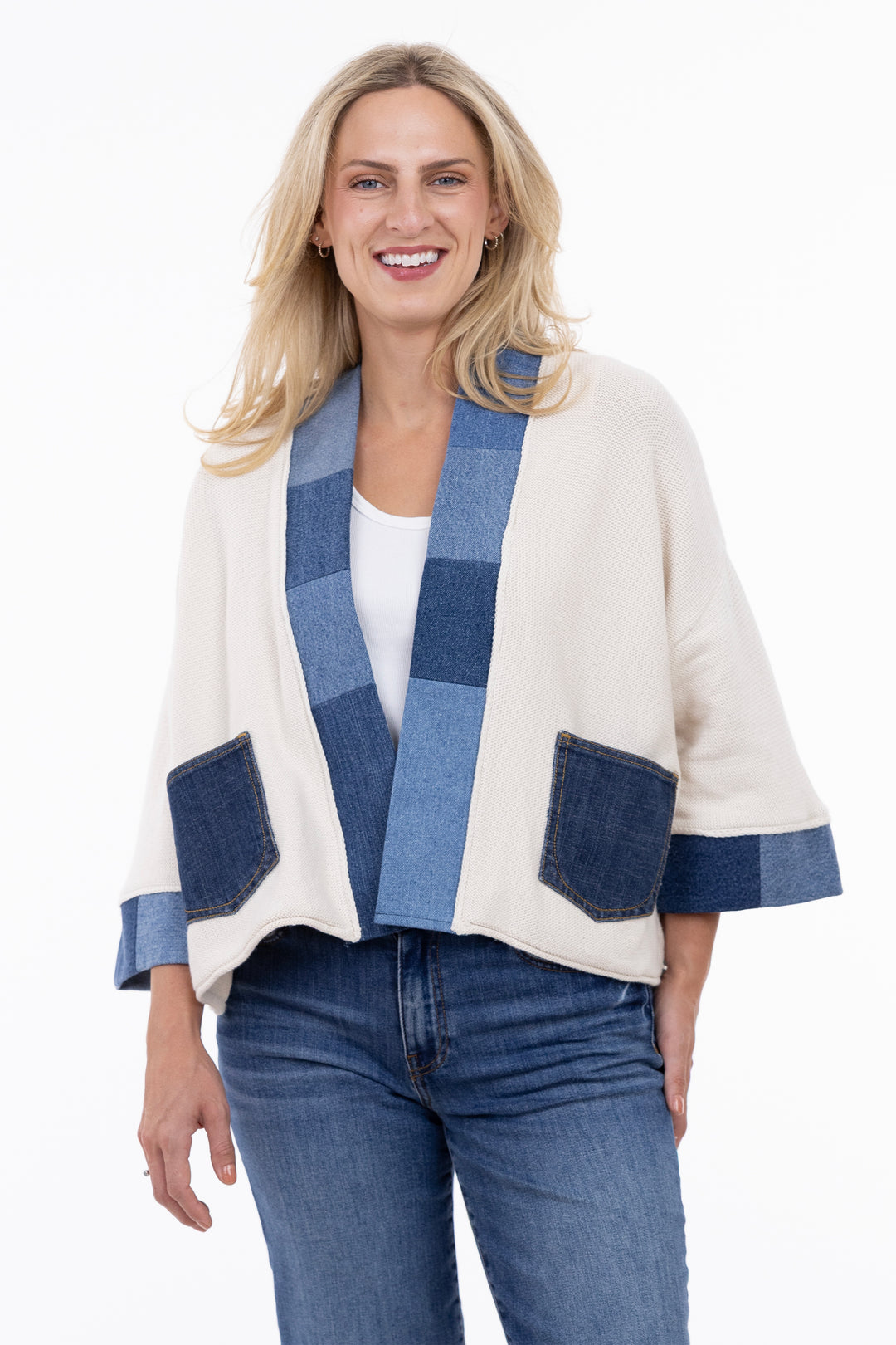 Woman wearing a white cardigan with blue patchwork design and blue maple leaf on a white background