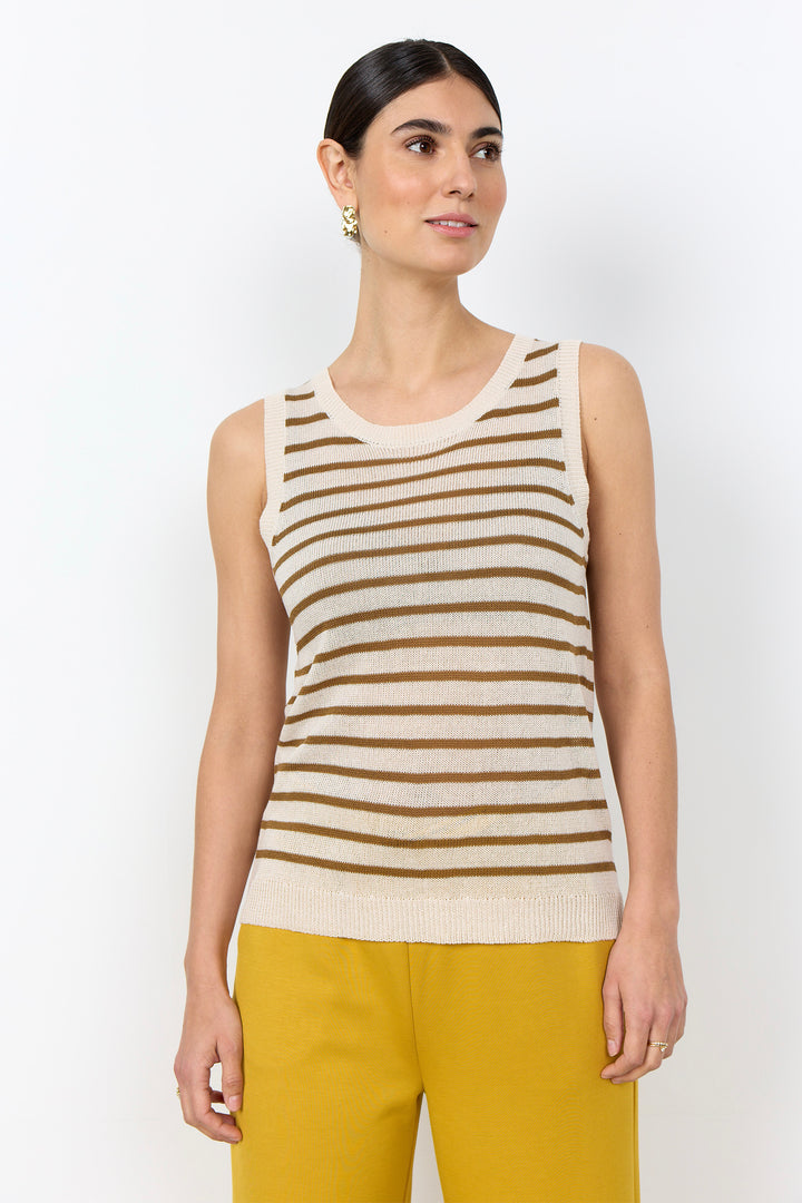 Woman wearing a stripe sleeveless top with yellow pants on a white background. 