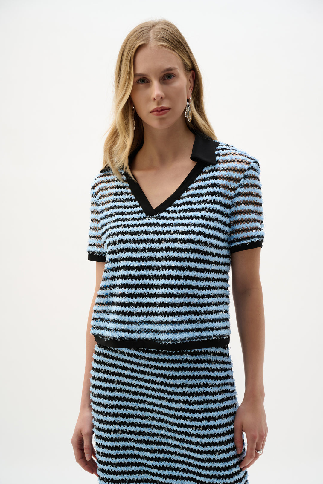 Woman wearing a black and blue striped set with a collar on a white background