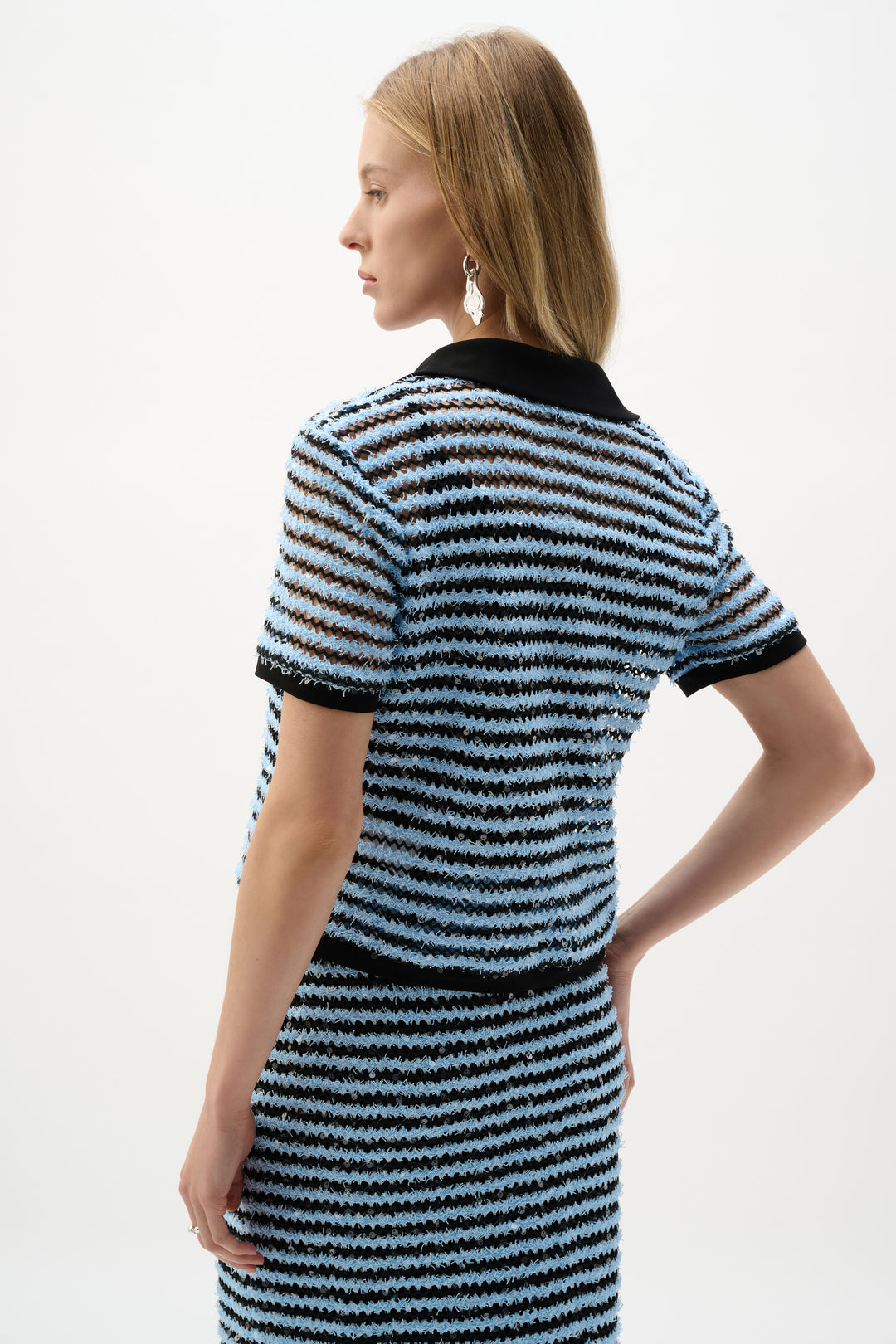 Woman wearing a black and blue striped set on a plain background