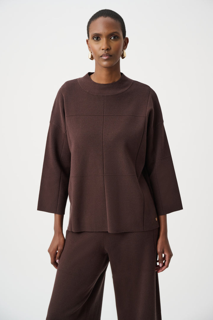 Woman wearing a brown light sweater top with 3/4 sleeves on a white background