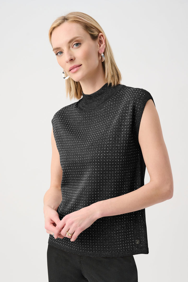 Woman wearing a black sleeveless top with a subtle pattern on a light gray background