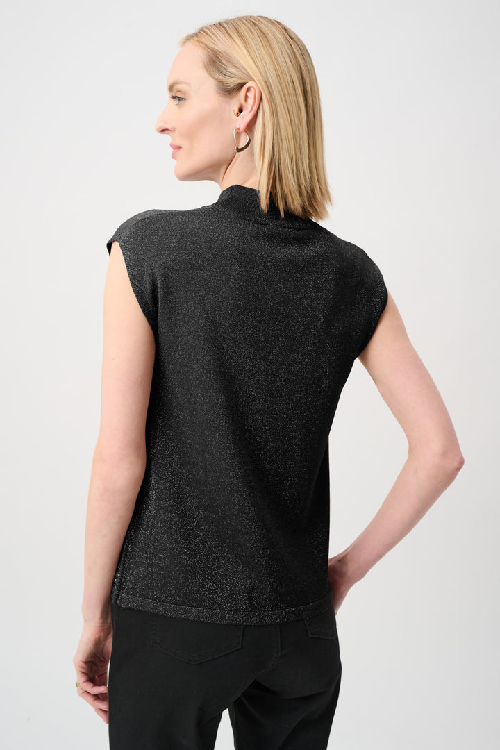 Woman wearing a black sleeveless top against a white background