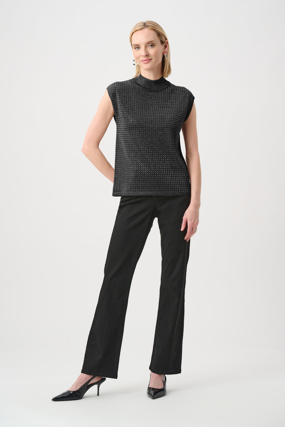 Woman wearing a black sleeveless top and black pants on a white background