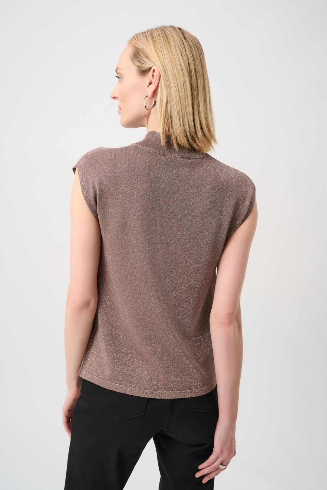Woman wearing a brown sleeveless top against a white background
